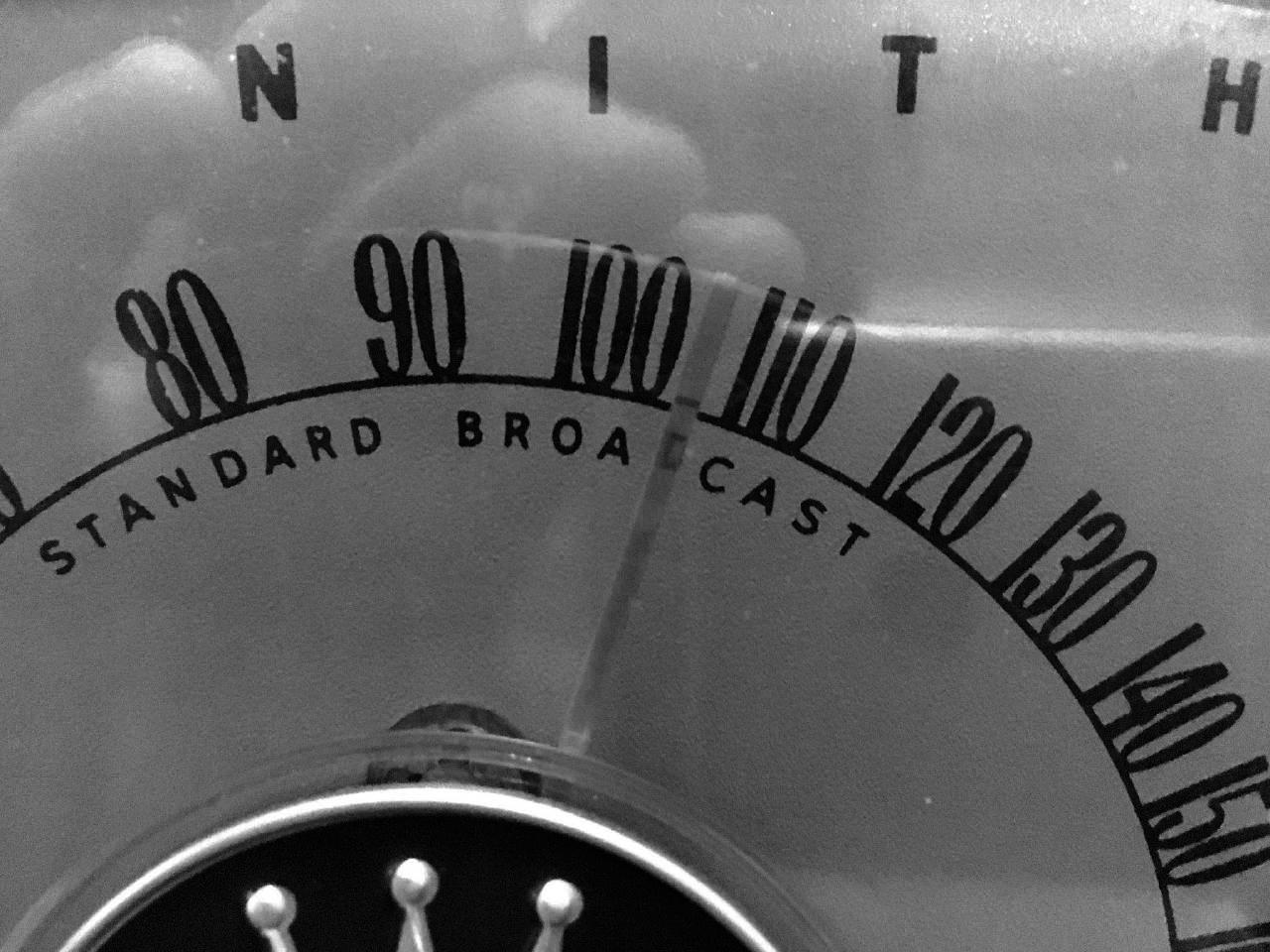 Image depicts a vintage Zenith radio dial with a needle pointing between 100 and 110 on the dial.